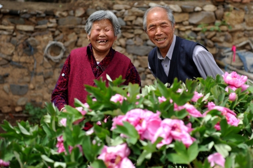 　5月13日，許潤枕（右）和老伴兒董振賢在牡丹花前合影。