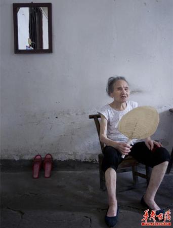 　90歲的王仲蓮如今已患有間歇性的老年癡呆，時而清醒、時而糊涂。圖為王仲蓮老人靜坐在屋內(nèi)，搖著蒲扇。