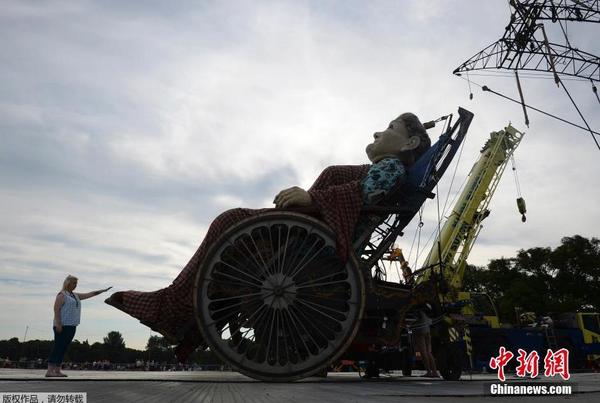 當?shù)貢r間2014年7月25日，為紀念第一次世界大戰(zhàn)爆發(fā)100周年，英國利物浦市迎來法國著名木偶劇團皇家豪華的3個巨型木偶，聆聽木偶們講述的一戰(zhàn)故事。圖為身高7.5米的“老奶奶”。1