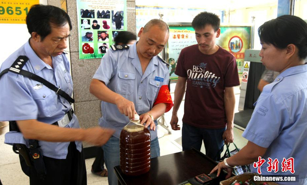 資料圖：7月29日，公安民警和安保人員正在克拉瑪依客運站進(jìn)站口嚴(yán)查進(jìn)站旅客行李和違禁物品。 周建玲 攝