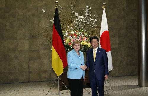 3月9日，在日本東京首相官邸，日本首相安倍晉三（右）歡迎到訪的德國總理默克爾。新華社發(fā)