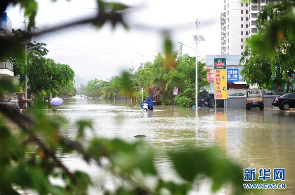 6月23日，在海南省三亞市，人們?cè)诜e水路段涉水前行。今年第8號(hào)臺(tái)風(fēng)“鯨魚”已于6月22日18時(shí)50分左右在海南省萬寧市沿海登陸，臺(tái)風(fēng)給三亞帶來了強(qiáng)風(fēng)降雨天氣，影響市民正常出行。新華社發(fā)（沙曉峰 攝）