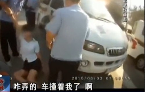 在拉扯中，女子撞到警車上。