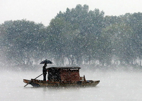 12月5日，杭州降下2015年入冬第一場雪。沒有一點(diǎn)點(diǎn)防備，杭州的初雪就洋洋灑灑地飄落了，雪越來越大，氣溫也驟降，西湖的水面上飄起層層白霧，與雪花攪在一起，如夢似幻。林云龍 視覺中國