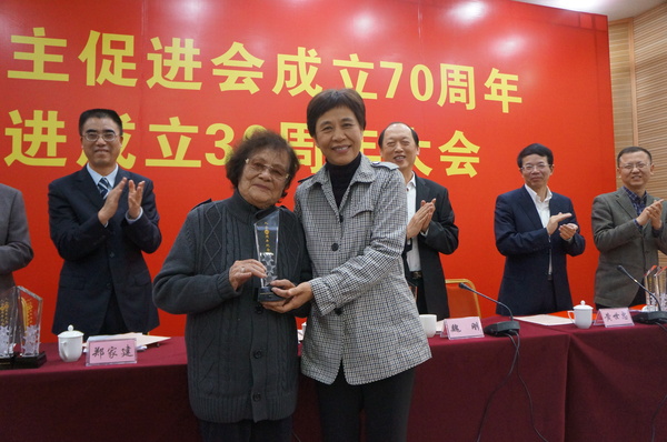 廈門市統(tǒng)戰(zhàn)部部長黃菱給入會60周年97歲高齡的民進(jìn)會員謝植桂頒發(fā)榮譽(yù)獎杯。