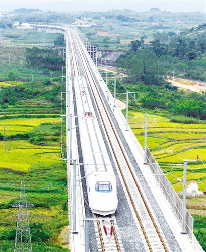 　12月3日，一輛試運行的“和諧號”列車從廣西南寧市隆安縣境內(nèi)的一座高架橋經(jīng)過。韋萬忠攝（新華社發(fā)）