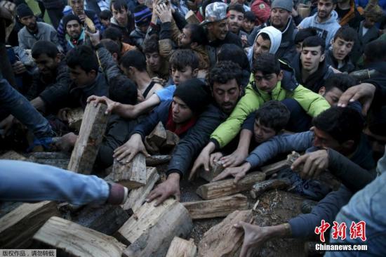 當(dāng)?shù)貢r(shí)間2016年3月6日，希臘Idomeni，滯留希臘與馬其頓邊境的移民蜂擁爭(zhēng)搶木柴。