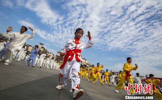 少年太極拳愛好者在江西都昌縣一廣場(chǎng)上表演太極拳?！「到ū蟆z