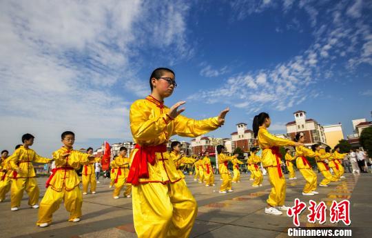 身著黃色統(tǒng)一古式服裝的少年打太極拳。　傅建斌　攝