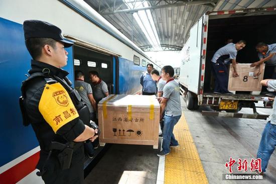 圖為6月29日，在北京站，文物保護(hù)人員將?；韬钗奈锇徇\(yùn)上列車(chē)。 張學(xué)東 攝