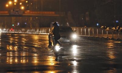 昨日，大望路，行人正在冒雨過人行道。 新京報記者 王飛 攝