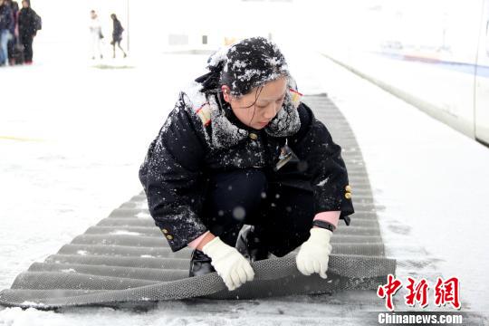 圖為鐵路工作人員在站臺上鋪設(shè)防滑墊?！∏劓z