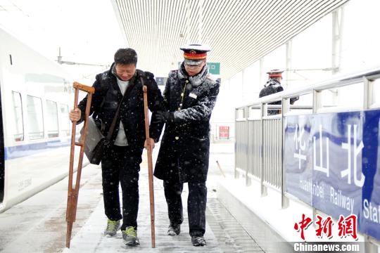 圖為鐵路工作人員幫助旅客進站。　秦姝　攝