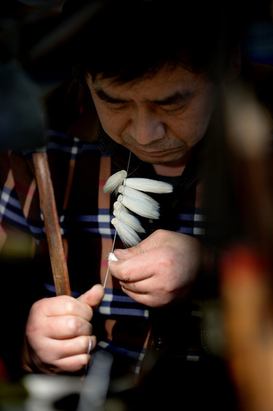 一位師傅在進(jìn)行捆頭工序的制作。