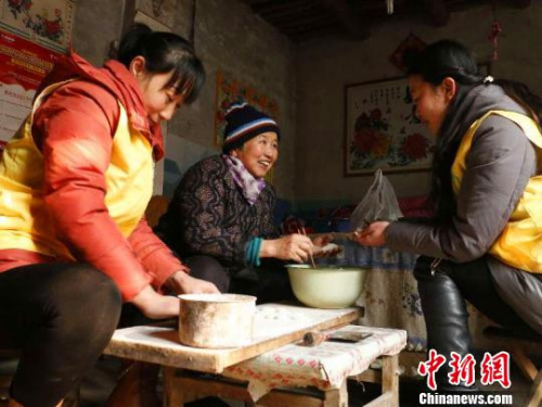 資料圖：除夕，巨鹿縣居家養(yǎng)老服務中心工作人員王勝晨、陳云彩和失獨老人張會群一起包餃子?！⊥醣麖?攝