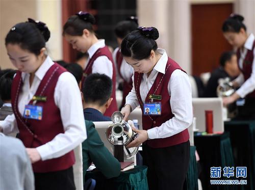 3月6日，北京華北賓館的女服務(wù)員在民盟、無黨派人士界委員聯(lián)組會(huì)上倒水。在兩會(huì)會(huì)場(chǎng)內(nèi)外，女代表、女委員、女工作人員、女記者在工作中盡職盡責(zé)，展現(xiàn)著自己的風(fēng)采。 新華社記者張鐸攝