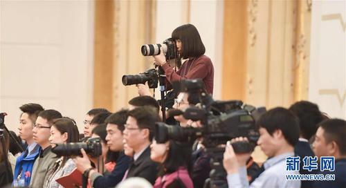 3月7日，一名女記者在十二屆全國人大五次會(huì)議江蘇代表團(tuán)全體會(huì)議上采訪拍攝。在兩會(huì)會(huì)場(chǎng)內(nèi)外，女代表、女委員、女工作人員、女記者在工作中盡職盡責(zé)，展現(xiàn)著自己的風(fēng)采。 新華社記者陳曄華攝