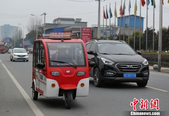 一位老者駕駛電動三輪車行駛在省道103線公路眉山段?！⒅铱?攝