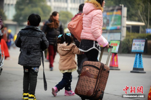 資料圖：2015年2月5日，2015年春運(yùn)第二天，江蘇揚(yáng)州市汽車西站迎來客流高峰，圖為家長帶著孩子在江蘇揚(yáng)州市汽車西站候車。 孟德龍 攝