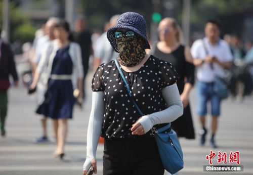 資料圖：5月17日，北京街頭的民眾防曬出行。當日北京市氣象臺發(fā)布今年首個高溫黃色預(yù)警。<a target='_blank' href='http://www.chinanews.com/'>中新社</a>記者 楊可佳 攝