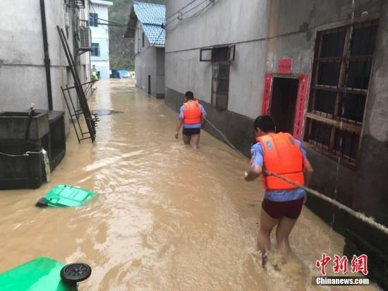 圖為浙江省麗水市遂昌縣民警在積水中準(zhǔn)備營(yíng)救居民。