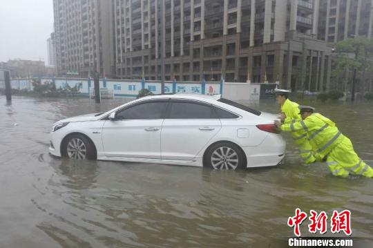 圖為：周宇和隊(duì)員在水中推拋錨的車(chē)。 金華公安供圖