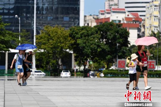 7月13日，廈門市民行走在熱浪滾滾的路面上。　張斌 攝