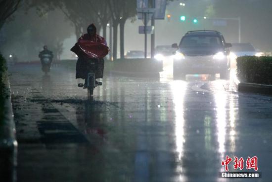 北京市民在雨中前行。 <a target='_blank' href='http://www.chinanews.com/'>中新社</a>記者 劉關(guān)關(guān) 攝