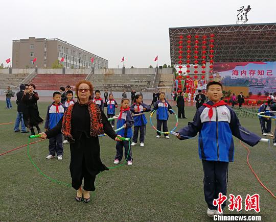 西班牙馬德里愛(ài)華中文學(xué)校校長(zhǎng)黃小捷饒有興致地與學(xué)生進(jìn)行跳繩比賽?！罱苡?攝