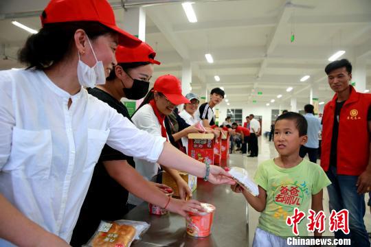 8月24日，志愿者在濰坊壽光市營里鎮(zhèn)第二初級中學(xué)安置點為災(zāi)民發(fā)放救援物資?！×籂?攝