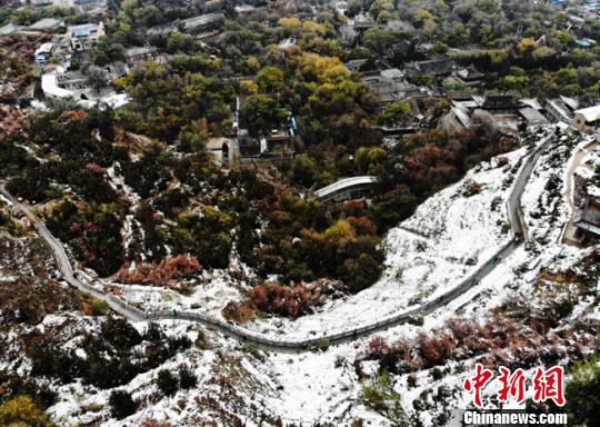 11月4日早晨，航拍視角中的蘭州城區(qū)一角，繽紛秋色中點(diǎn)綴著點(diǎn)點(diǎn)白雪?！钇G敏 攝