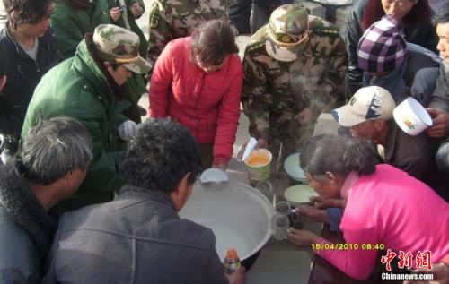 官兵在營地與災民共同吃飯。武警玉樹支隊 趙飛 供圖