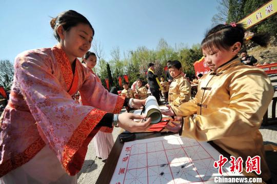 圖為曲阜舉行學(xué)童啟蒙開筆禮儀式?！∏肥形麄鞑抗﹫D 攝