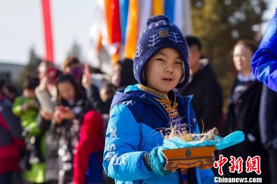 圖為小孩拿著貢品準(zhǔn)備祭火?！『?攝