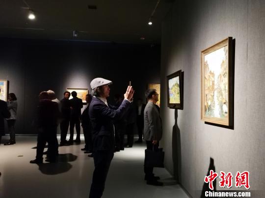 圖為，在“印象山東——俄羅斯油畫家寫生作品展”上，觀眾在喜歡的作品前駐足觀賞、拍照?！O宏瑗 攝