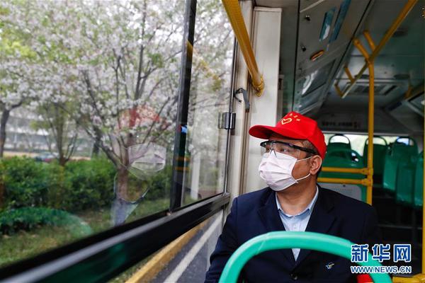 　3月25日，在武昌火車站綜合體站始發(fā)的首趟518路公交車上，安全員熊偉望著窗外路邊的櫻花。 當(dāng)日起，武漢市部分公交車恢復(fù)開行。 新華社記者 沈伯韓 攝